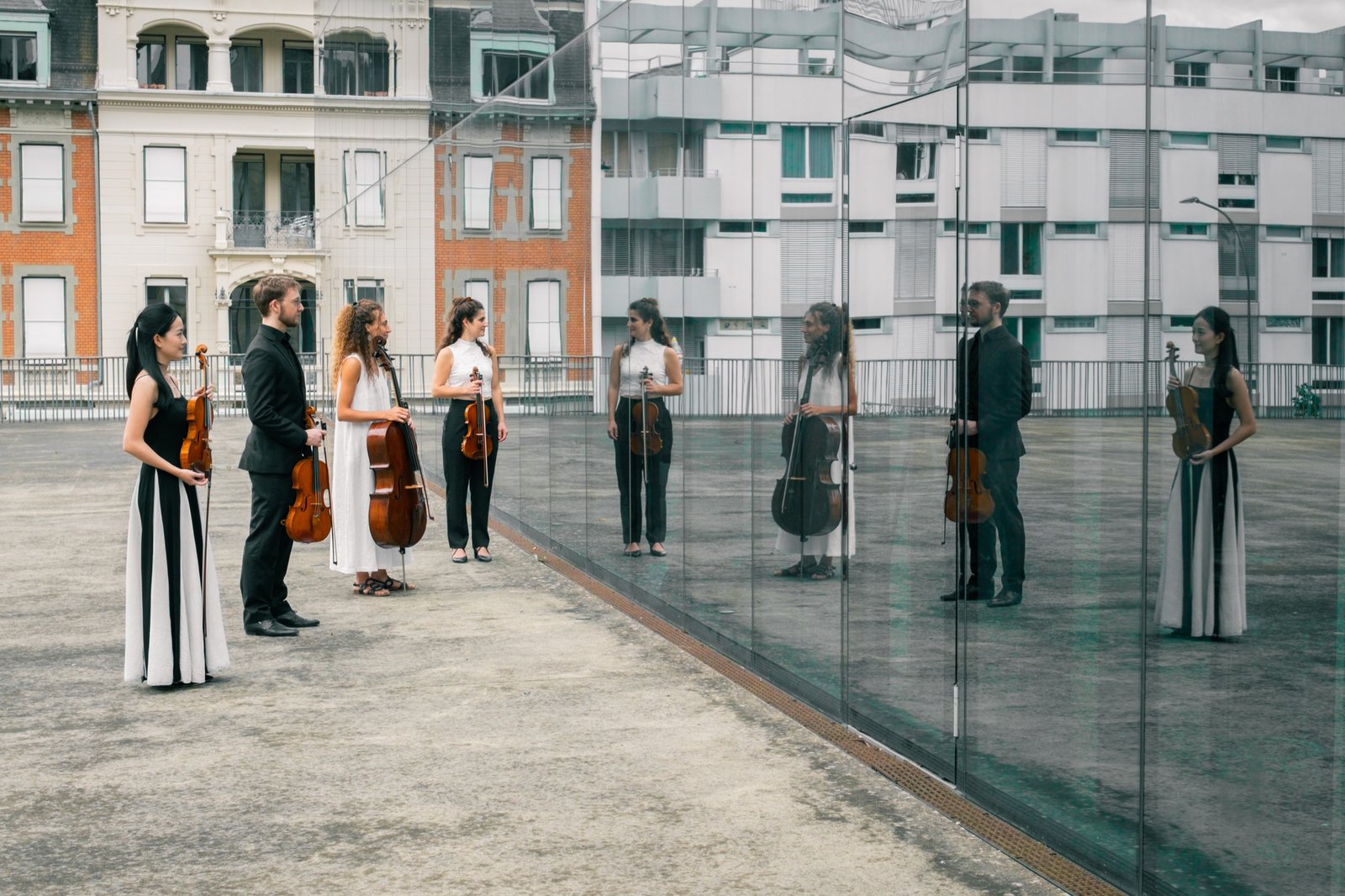 Das merisma quartett und seine Spiegelbilder vor einer Glasfassade